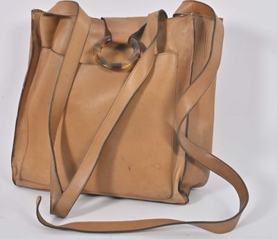 tan leather handbag with handle and strap on white background