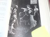 un livre ouvert sur lequel figure le dessin d'une femme pointant une arme sur un homme