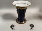une paire de vases noirs et dorés posés sur une table blanche