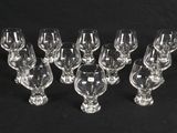 six clear wine glasses are lined up on a black surface