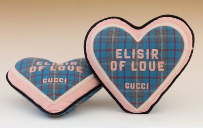 two heart shaped cushions with the words flisir of love on them