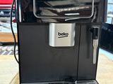 une photo d'une machine à café noire posée sur une table en bois