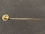 a gold pin with a horse on it on a black surface