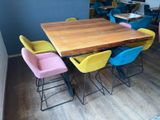 brightly colored chairs sit around a wooden table in a room