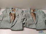 two suits that are sitting on a white table
