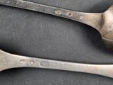 two spoons that are sitting next to each other on a table