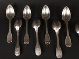 six silver spoons are lined up in a row on a black surface