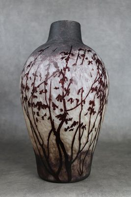 un vase noir et blanc orné d'un motif représentant un arbre