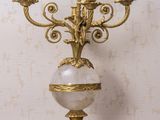 un candélabre en or surmonté d'une boule de marbre