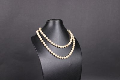 un collier de perles blanches sur un mannequin noir
