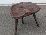 a small wooden stool sitting on top of the pavement