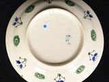 a white plate with blue and green designs on it