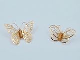 une paire de boucles d'oreilles papillon en or sur fond blanc