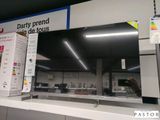 un homme en train de prendre une photo d'un téléviseur dans un magasin
