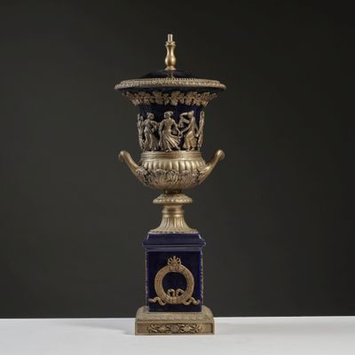 an antique blue and gold urn with figures on it