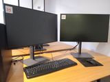 two computer monitors and a keyboard on a desk