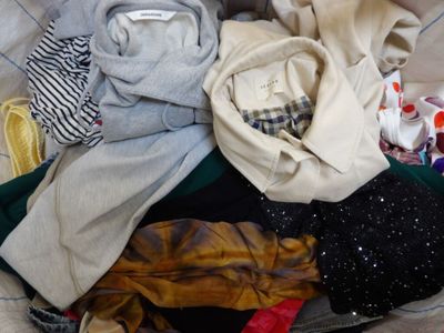 a pile of clothes sitting in a suitcase on a bed