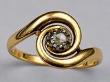 a close up of a gold ring with a diamond in it