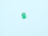 a green emerald stone on a white surface