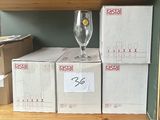 several boxes of wine glasses are stacked on a shelf in a store