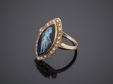 a gold ring with an image of a woman and pearls