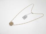a close up of a necklace on a white surface with a price tag