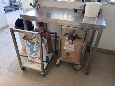 a kitchen with a stainless steel table and two bags of food on it