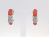 une paire de boucles d'oreilles en corail et diamants, présentée sur un présentoir transparent