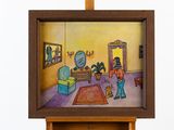 une photo d'un tableau posé sur un chevalet, avec une photo d'une personne dans un salon