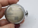 a person holding a silver pocket watch in their hand