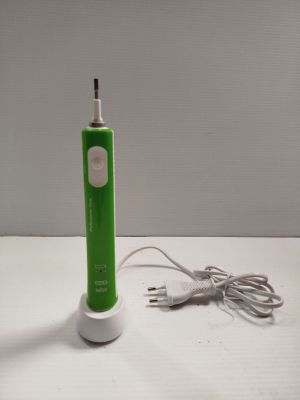 a green electric toothbrush sitting on a white table