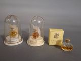 three miniature bottles of perfume sitting on top of a table next to a box of perfume