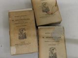 three old books sitting on top of a table next to each other