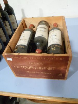 plusieurs bouteilles de vin se trouvent dans un coffret en bois sur une table