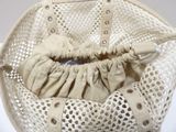 a white purse with a handle and a bag inside of it