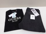 un jean Guess posé sur une table, à côté d'un t-shirt