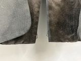 un pantalon gris suspendu à un cintre sur un mur blanc