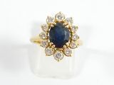 a close up of a gold ring with a sapphire and diamonds