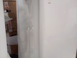 a white refrigerator sitting in a room with boxes on the floor