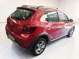 the back end of a red car parked in a white room