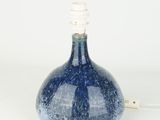 a blue vase that has a light on top of it