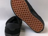 black slip on shoes with a rubber sole on a white surface