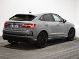 the rear end of a silver audi suv parked in a white room