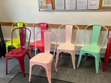 several colorful chairs are lined up against a bulletin board in a classroom