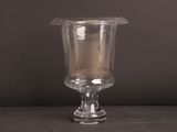 un vase en verre contenant une bougie, posé sur une table