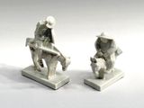 two figurines of a man and a woman sitting on a bench