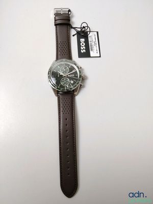 the watch has a brown leather strap and a black face