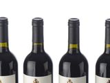 six bottles of wine are lined up in a row on a white surface