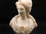 un buste en marbre blanc représentant une femme coiffée d'une couronne de fleurs