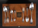 several spoons, forks, and spoons are arranged in a wooden box